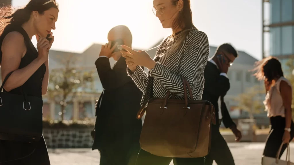 People walking using cell phones